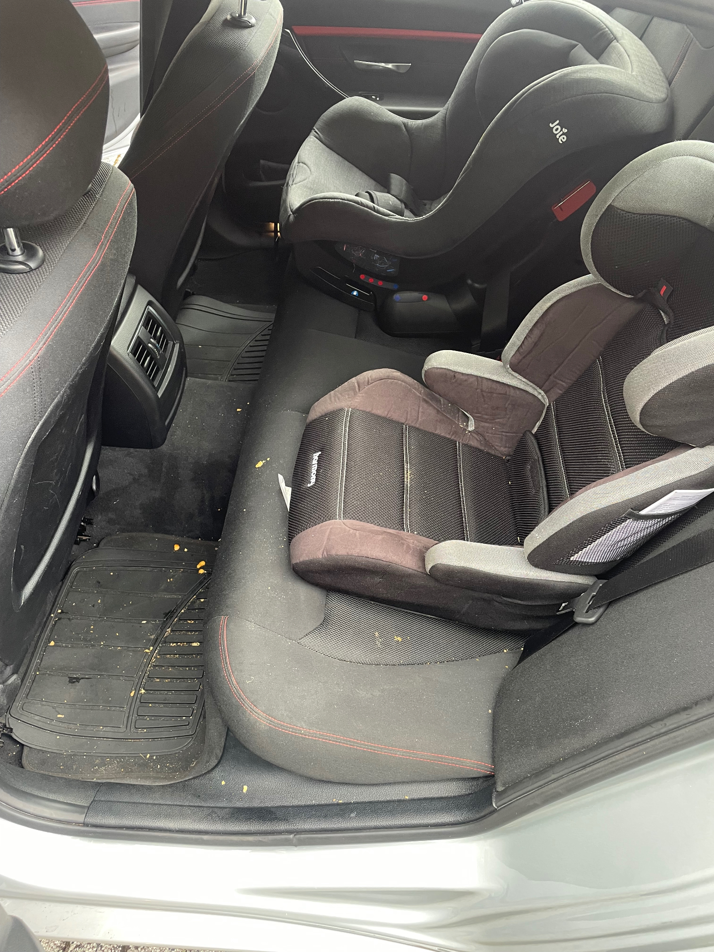 Dirty car interior with child seats before an M&M Deluxe deep clean